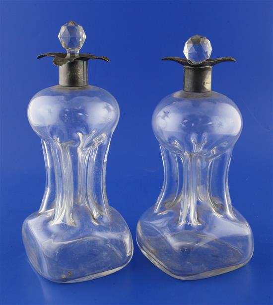 A near pair of Edwardian silver mounted four lipped waisted glass decanters with glass stoppers, 10.5in et infra.